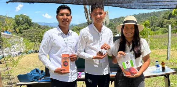  Estudiantes exponen sus productos durante una feria al aire libre.